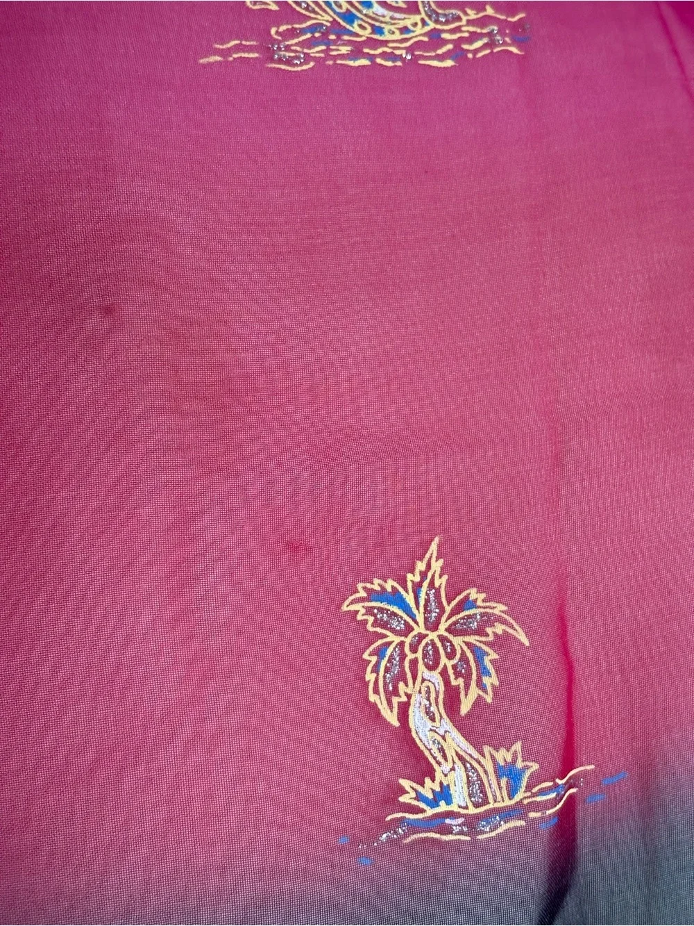 magenta and black scarf features palm tree motifs and black tassels along the ed